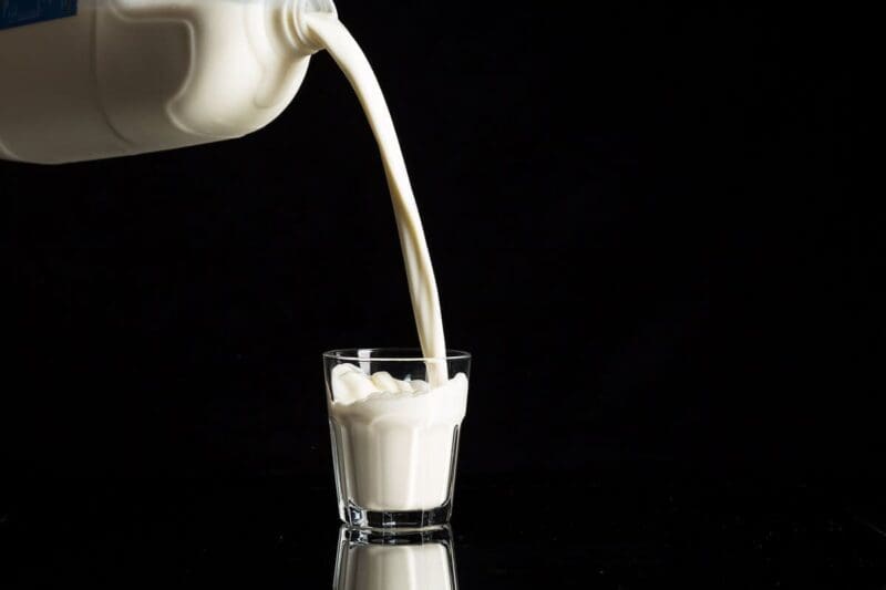 milk being poured into a glass from above
